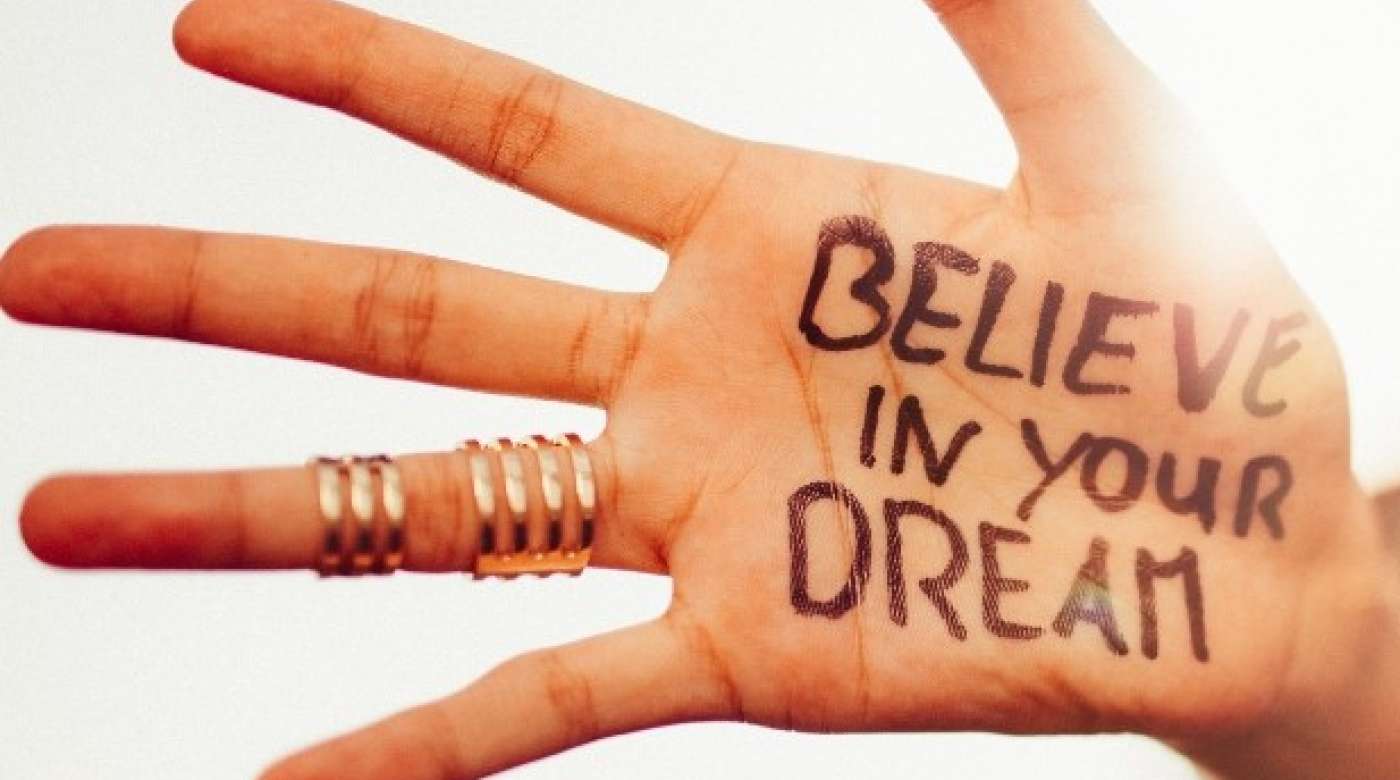 Hand with "believe in your dream" written on the palm
