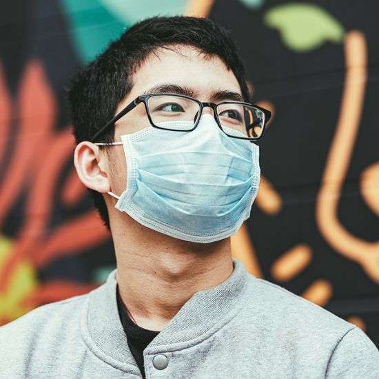 Teen wearing a surgical mask to protect from COVID-19.